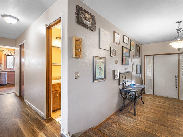 corridor featuring baseboards and wood finished floors