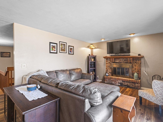 living area featuring a brick fireplace and wood finished floors