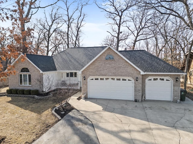 single story home featuring concrete driveway, a garage, brick siding, and a shingled roof