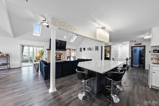 kitchen featuring white cabinets, open floor plan, a center island, and light countertops