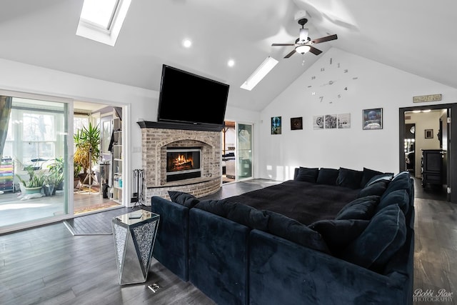 living area featuring a fireplace, a skylight, and wood finished floors