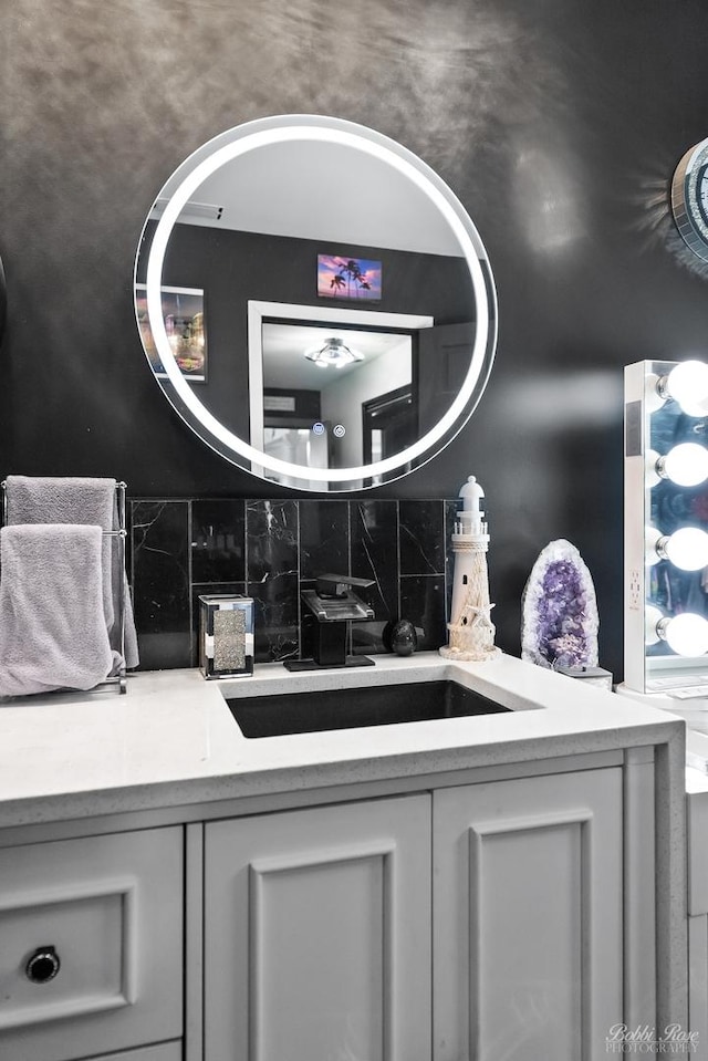 bathroom featuring a sink and backsplash