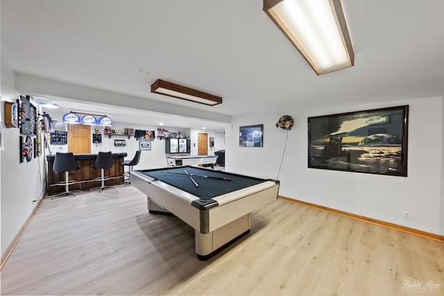 recreation room with light wood finished floors, a dry bar, pool table, and baseboards