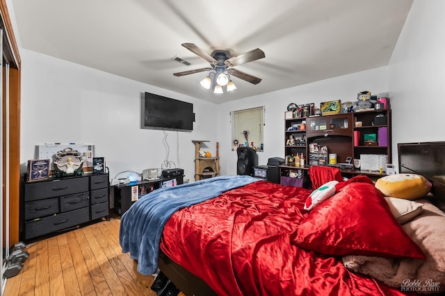 bedroom with ceiling fan, visible vents, and hardwood / wood-style floors