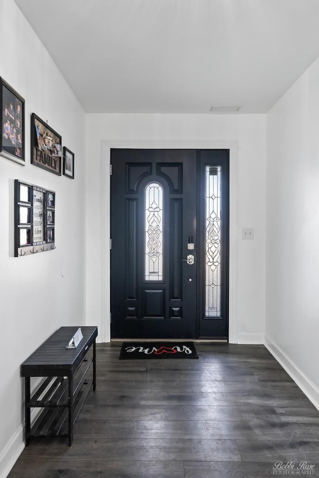 foyer with visible vents, baseboards, and wood finished floors