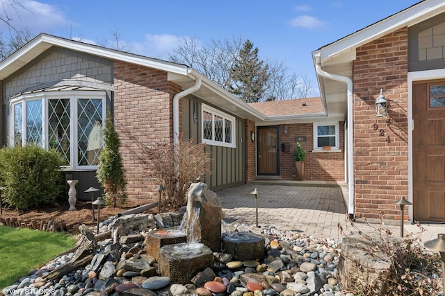 view of home's exterior with brick siding and roof with shingles