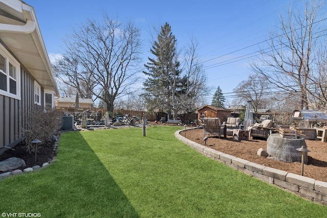 view of yard with central AC and fence