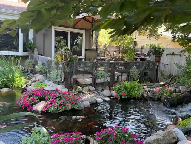 view of yard featuring a garden pond and fence