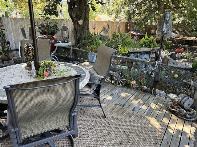 deck with a fenced backyard and outdoor dining space