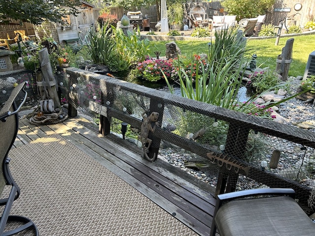 wooden deck with a small pond and fence