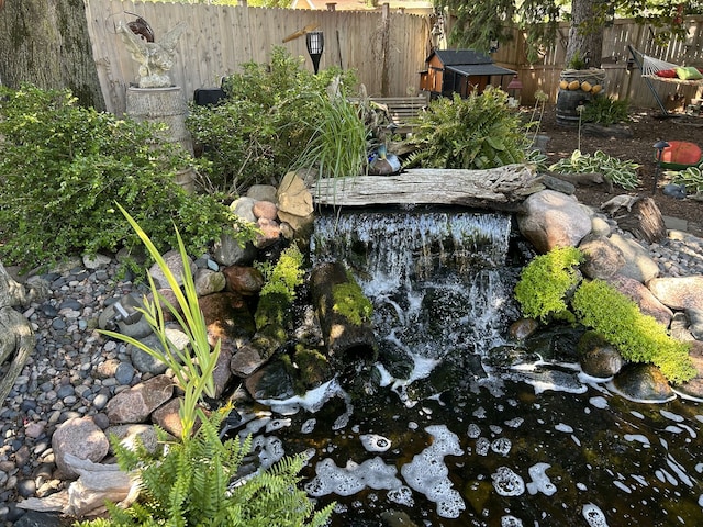 details featuring a garden pond and fence