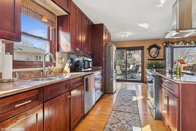 kitchen with a sink, island exhaust hood, reddish brown cabinets, and stainless steel appliances