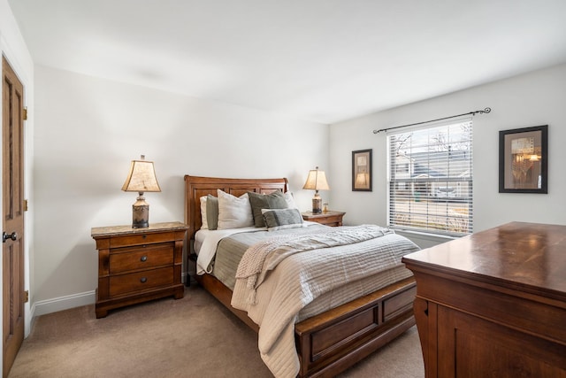 bedroom featuring light carpet and baseboards