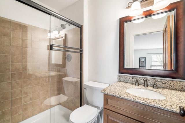 full bath featuring a stall shower, vanity, and toilet