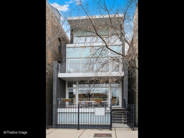 view of front of house featuring brick siding and a balcony