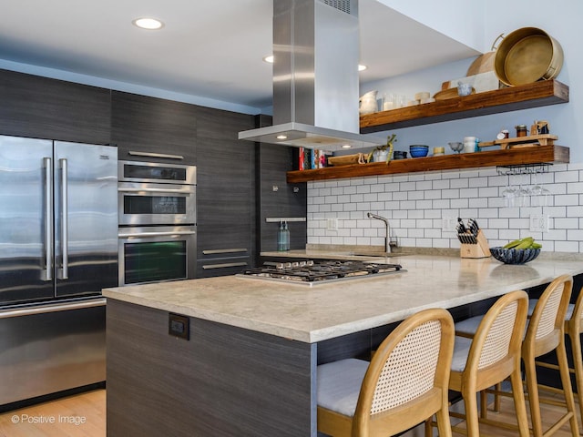 kitchen with modern cabinets, island exhaust hood, stainless steel appliances, open shelves, and backsplash