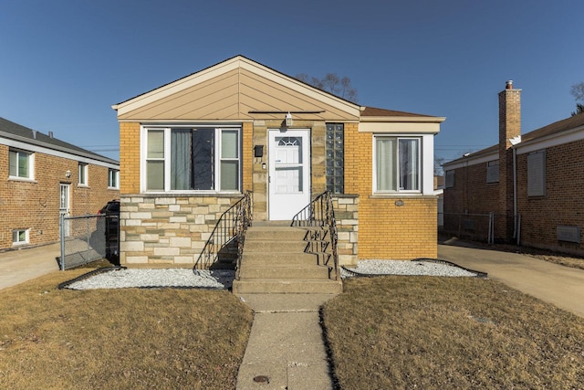 bungalow with brick siding and fence