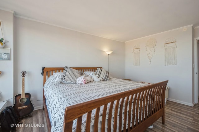 bedroom featuring crown molding, wood finished floors, and baseboards