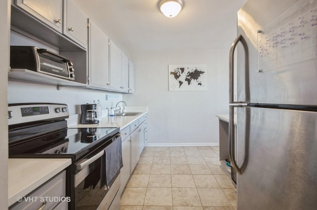 kitchen with light tile patterned flooring, appliances with stainless steel finishes, light countertops, and a sink