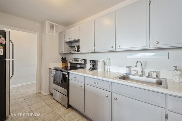 kitchen with visible vents, a sink, appliances with stainless steel finishes, light countertops, and light tile patterned floors