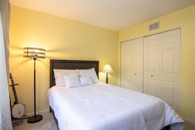 carpeted bedroom featuring a closet, visible vents, and baseboards