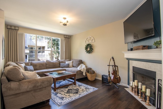 living room with dark wood-style floors, baseboards, and a tiled fireplace