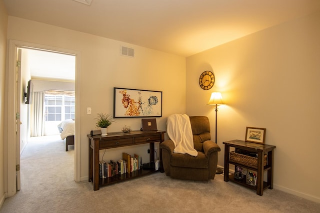 living area with carpet flooring, visible vents, and baseboards