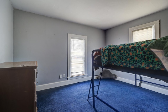 bedroom featuring dark carpet and baseboards