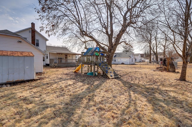 view of playground with a shed, an outdoor structure, and fence