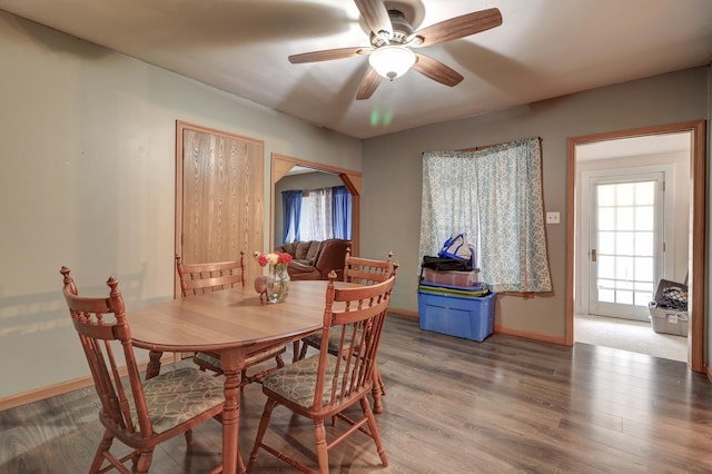 dining room featuring a ceiling fan, baseboards, and wood finished floors