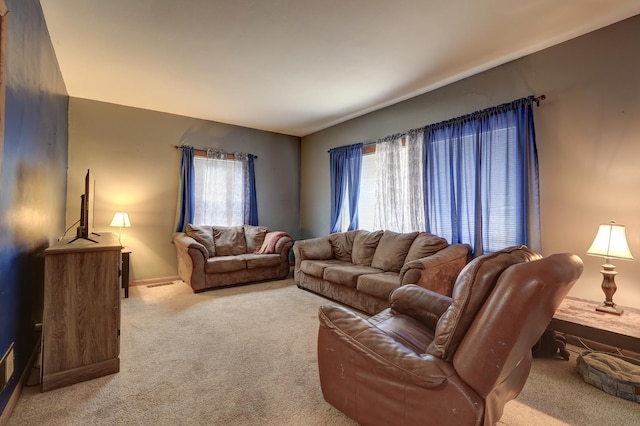 living room featuring visible vents, plenty of natural light, and light carpet