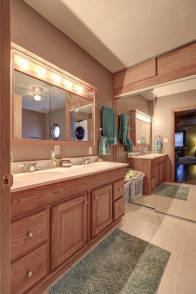 bathroom featuring a textured ceiling, double vanity, and a sink