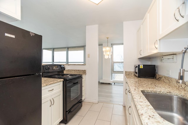 kitchen featuring a healthy amount of sunlight, white cabinets, and black appliances