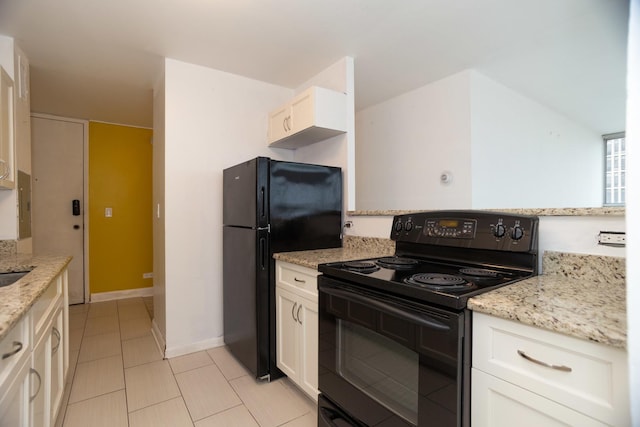 kitchen with light stone counters, baseboards, white cabinets, and black appliances