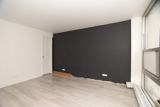 spare room featuring light wood finished floors and baseboards