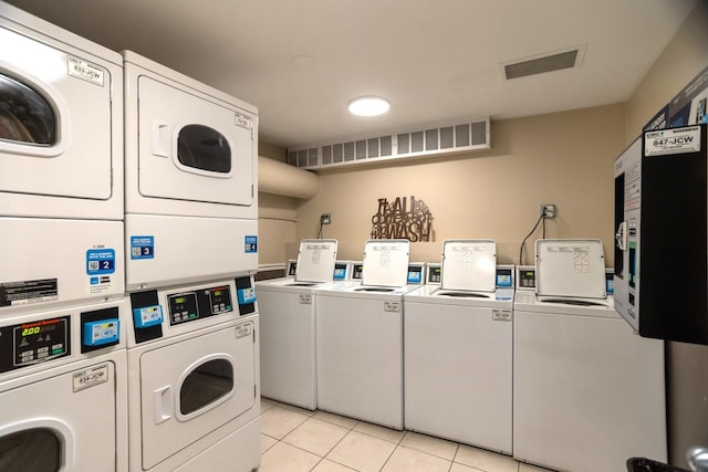 community laundry room with visible vents, light tile patterned floors, washing machine and clothes dryer, and stacked washer and clothes dryer