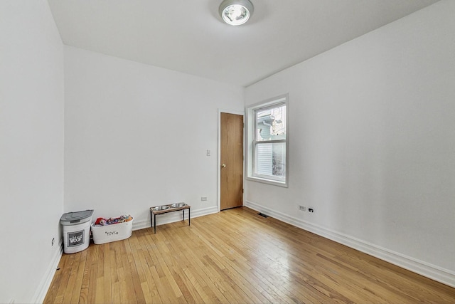 unfurnished room with visible vents, hardwood / wood-style flooring, and baseboards