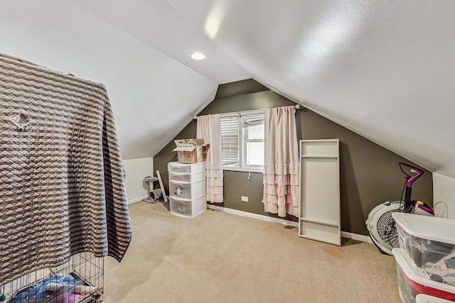 interior space featuring lofted ceiling, baseboards, and carpet flooring