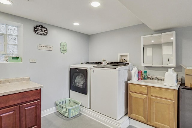 laundry room featuring recessed lighting, separate washer and dryer, a sink, baseboards, and cabinet space