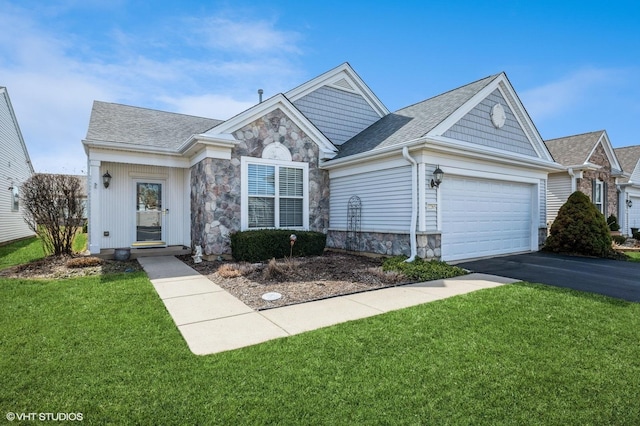 view of front of house featuring a front lawn, a garage, stone siding, and aphalt driveway