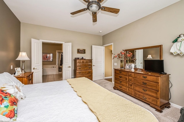 carpeted bedroom with ensuite bath, a ceiling fan, and baseboards