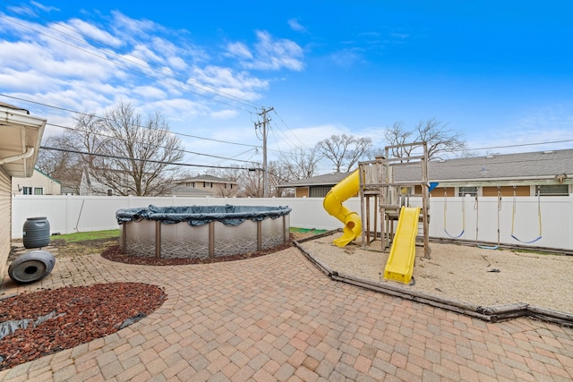 exterior space with a fenced backyard, a playground, and a fenced in pool