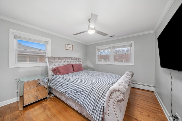 bedroom featuring a baseboard heating unit, visible vents, crown molding, and wood finished floors