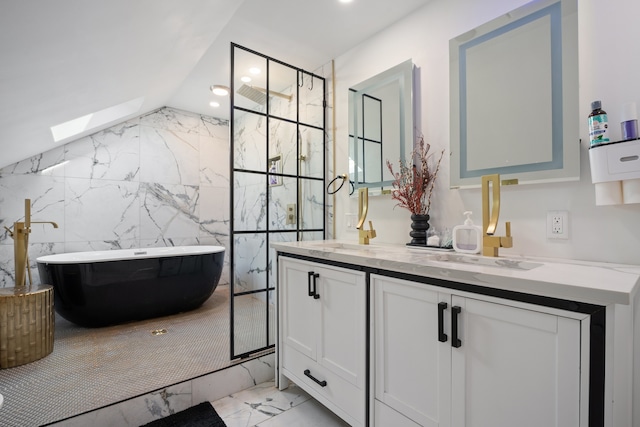 bathroom with double vanity, a freestanding tub, recessed lighting, lofted ceiling with skylight, and marble finish floor