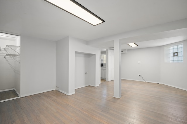 basement with baseboards and wood finished floors