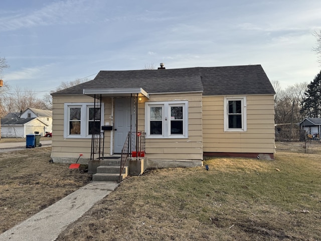 bungalow featuring a shingled roof and a front yard