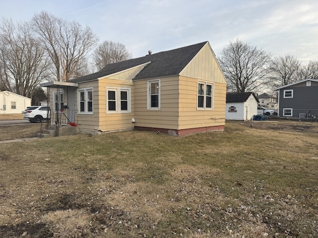 exterior space with a yard, a shingled roof, and board and batten siding