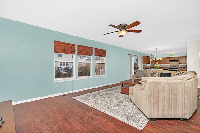 living room with ceiling fan with notable chandelier, dark wood-style flooring, visible vents, and baseboards