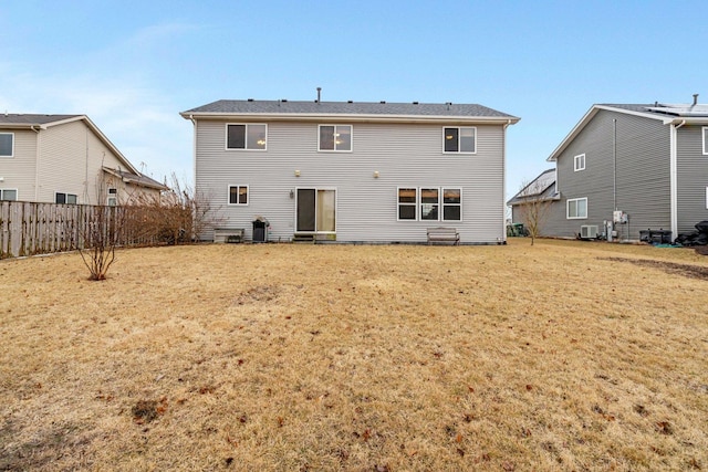 back of property with a lawn, fence, and central air condition unit