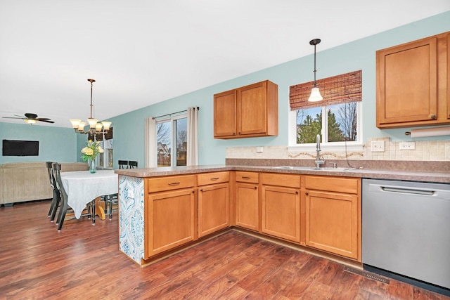 kitchen with dishwasher, a peninsula, dark wood-style flooring, and a sink